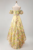 Vestido de invitad con alto y bajo con bordado floral amarillo y mangas abullonadas