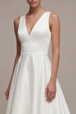 Un vestido de compromiso blanco alto y bajo de línea con escote en V