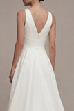 Un vestido de compromiso blanco alto y bajo de línea con escote en V