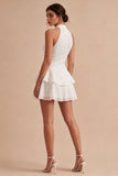 Un vestido mini blanco con volantes de escaleras con capas de lentejuelas y lentejuelas
