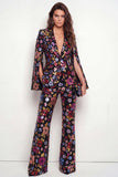 Trajes de mujer con solapas negras de pico con visera brillante, un botón floral de lentejuelas