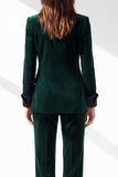 Traje de mujer verde oscuro con solapa de pico, botonadura sencilla y bolsillos