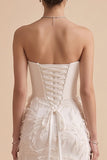 Vestido largo de novia blanco sin tirantes con plumas
