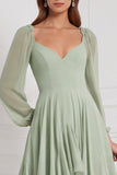 Vestido de gasa color salvia con corte en A, escote en V, mangas largas y volantes
